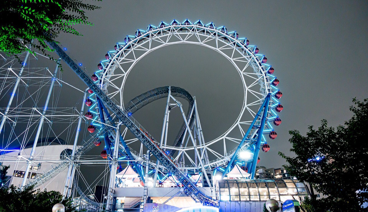 The Tokyo Dome City ferris wheel lit blue after dark.
