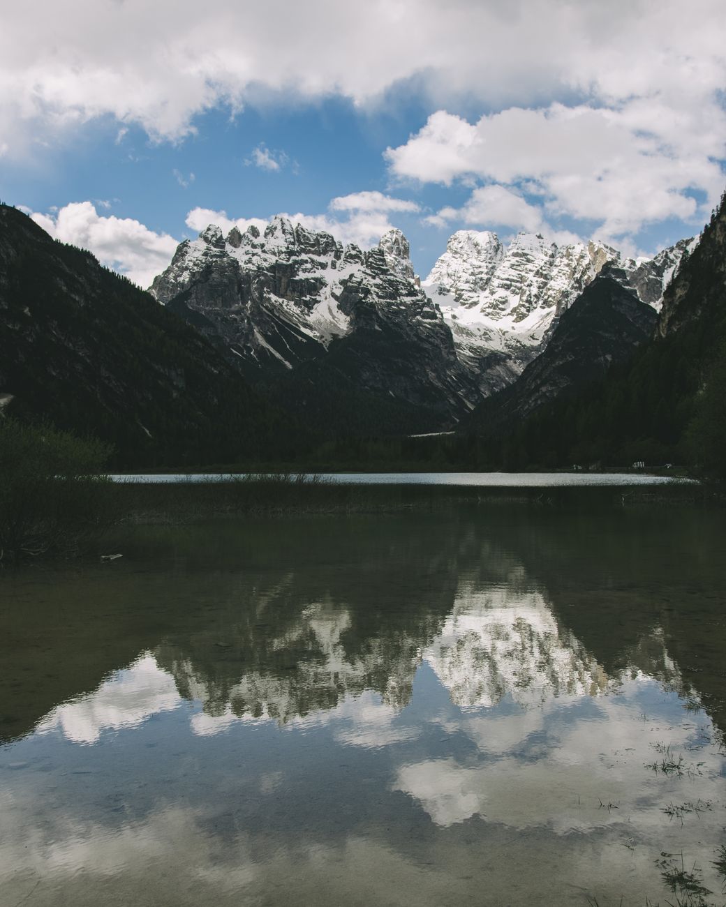 Still alpine lake reflecting the jagged Dolomite peaks