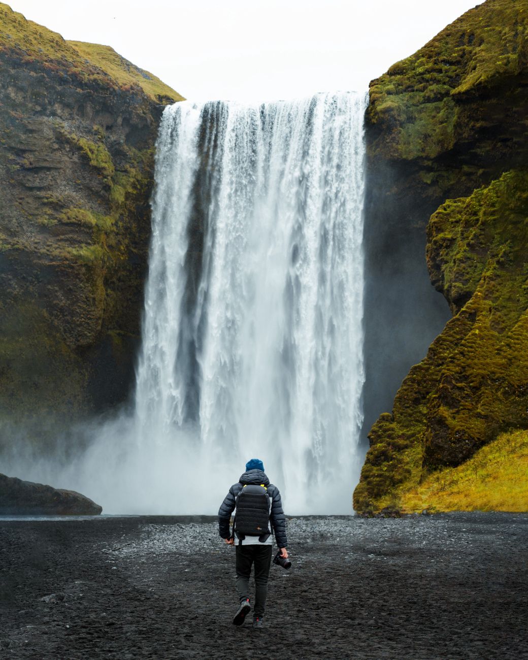 Skógafoss waterfall pouring over green cliffs on Iceland's south coast