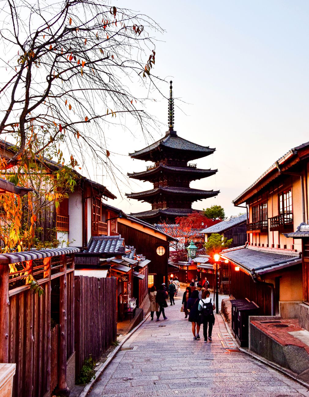 Wooden temple roofs rising above a quiet old-town lane in Kyoto