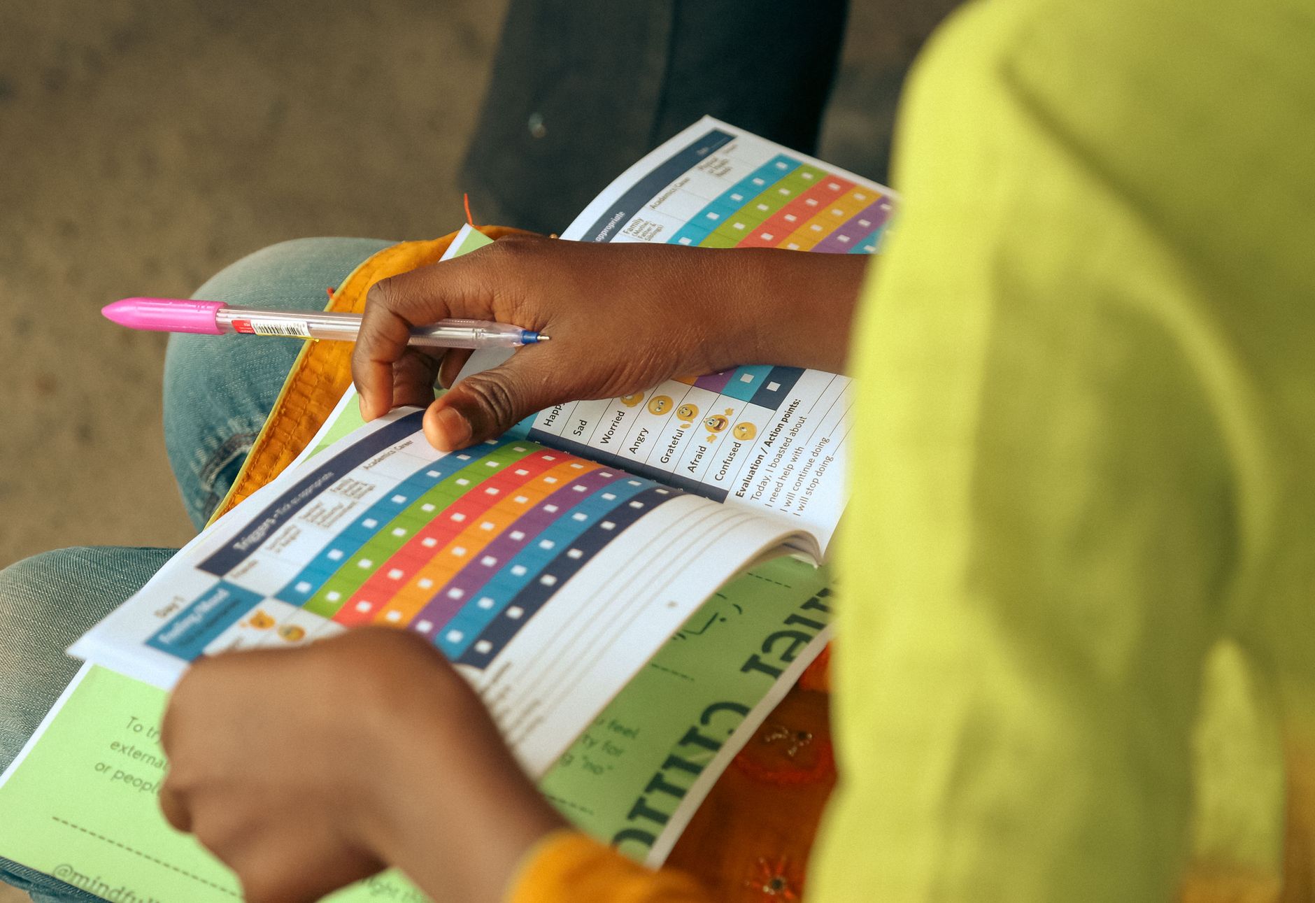 Hands holding a fan of colourful printed paper