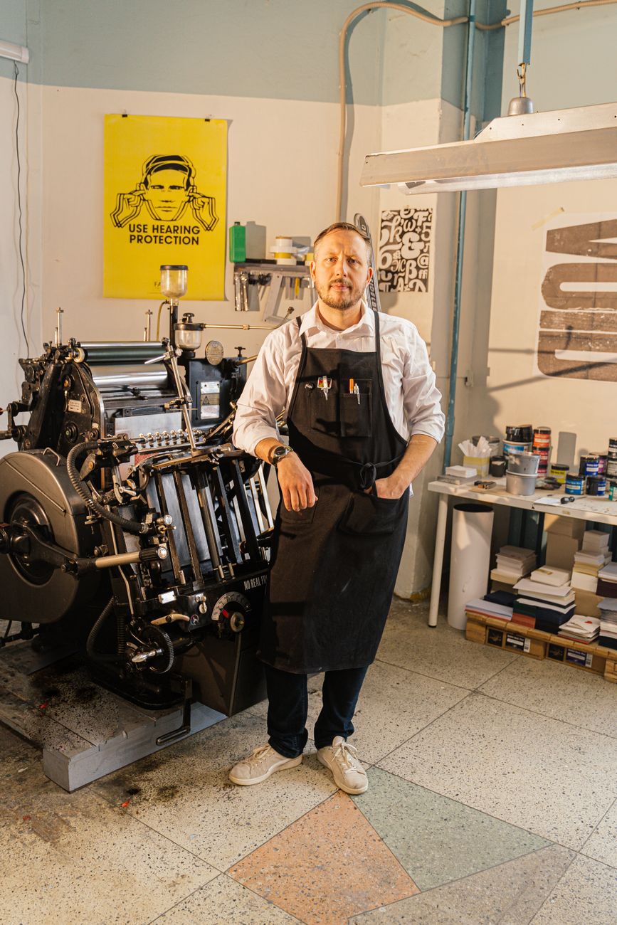 Mira standing beside the two-drum risograph in the studio