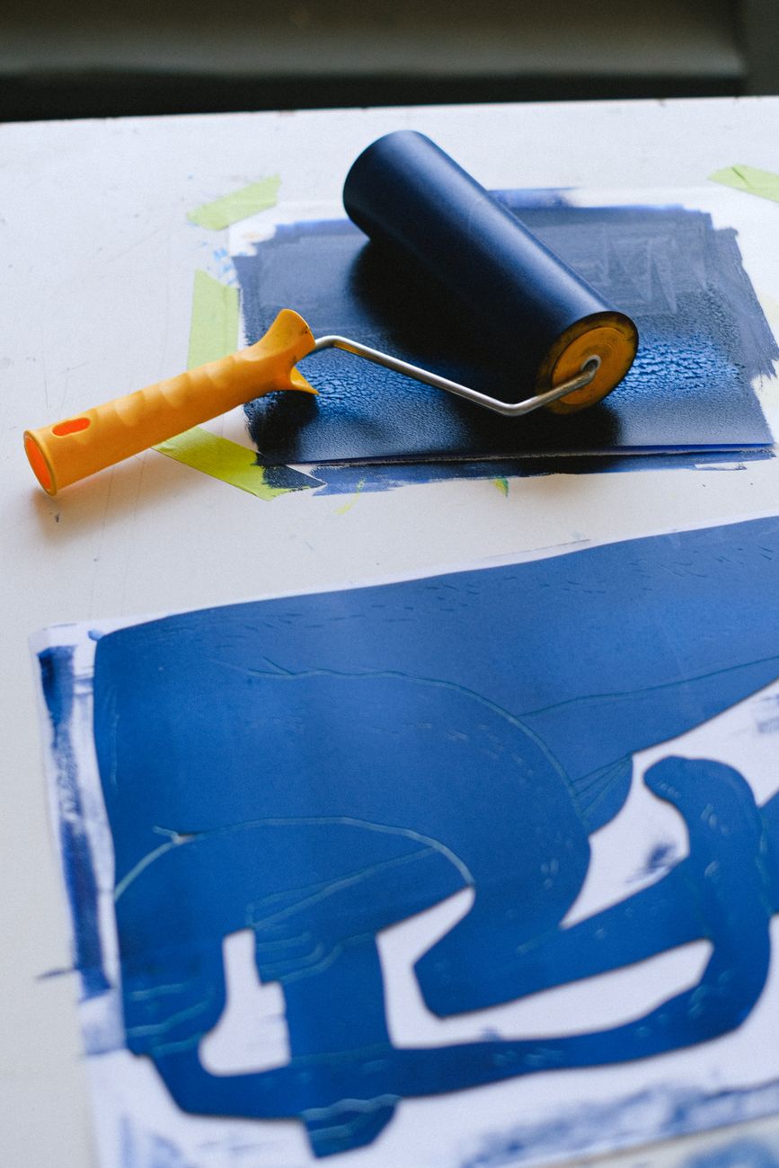 An ink roller resting on a freshly printed blue sheet