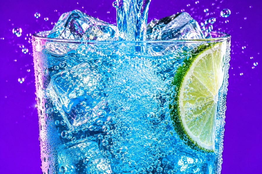 Soda pouring over ice in a glass