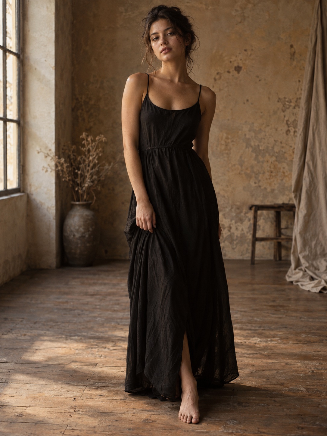Woman in a black dress in a warm daylight studio.