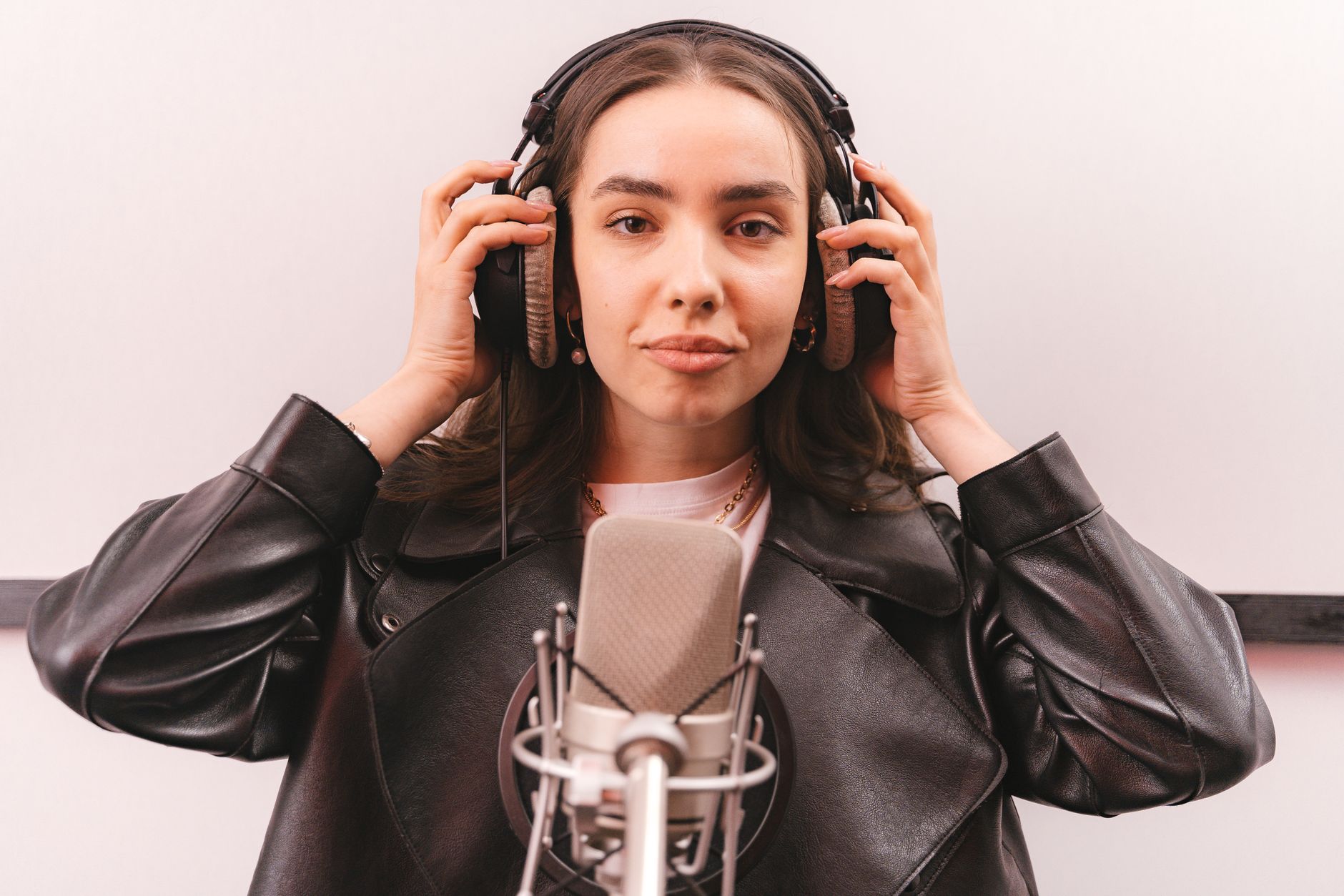 Juno Vale in the studio wearing headphones against a white backdrop