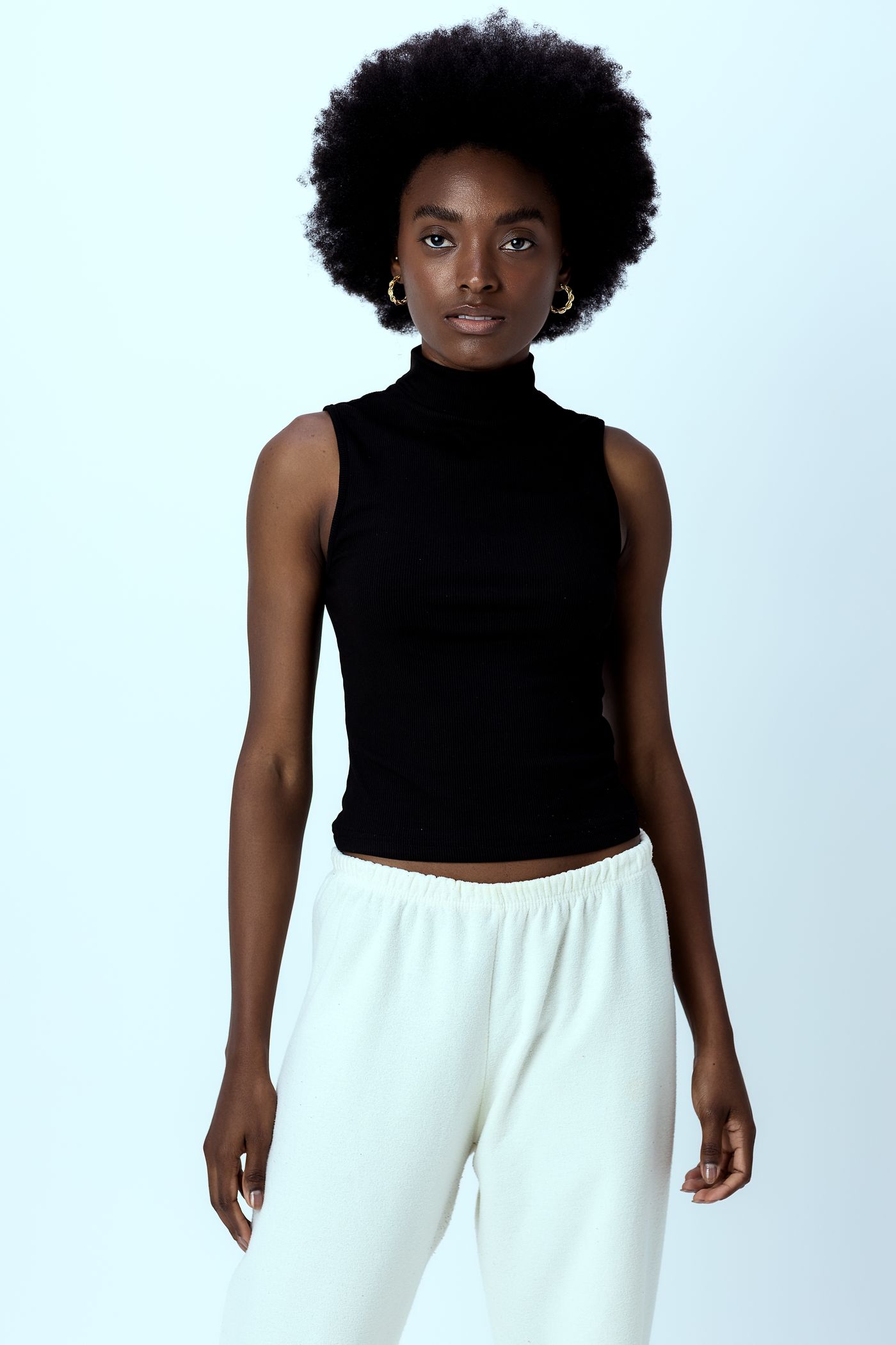 Black sleeveless mock-neck top in a studio