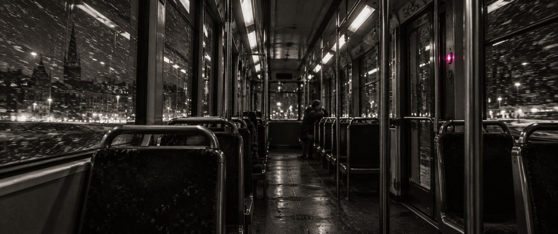The inside of a night tram, snow streaking past the windows
