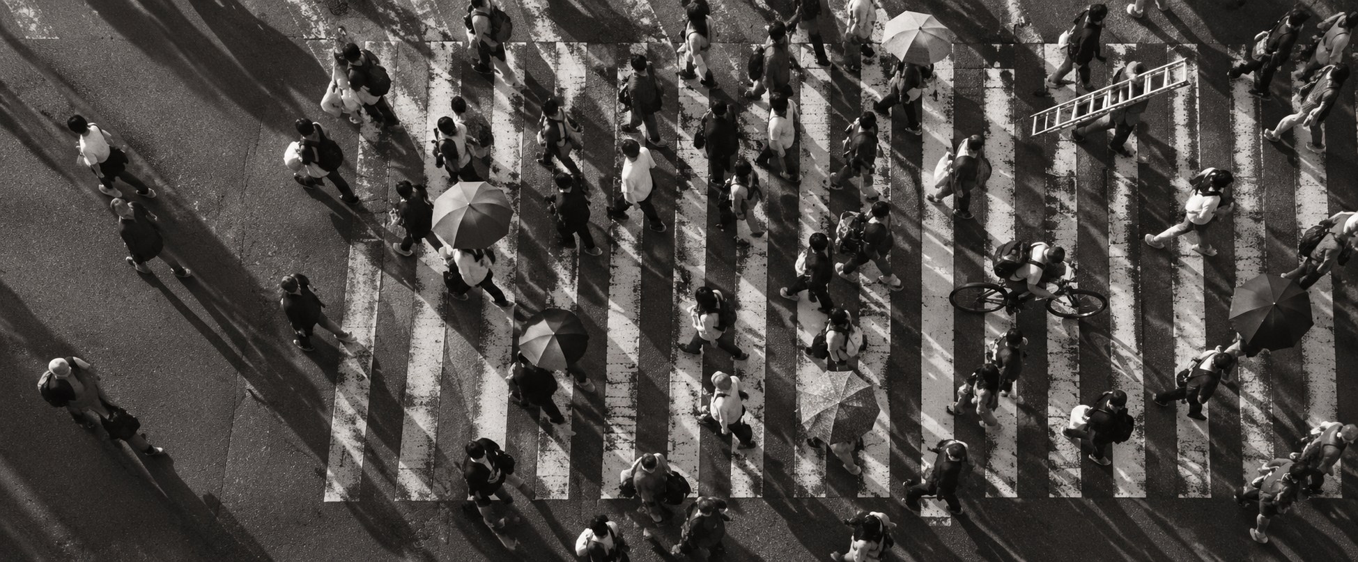 A busy street crossing seen from high above, people criss-crossing