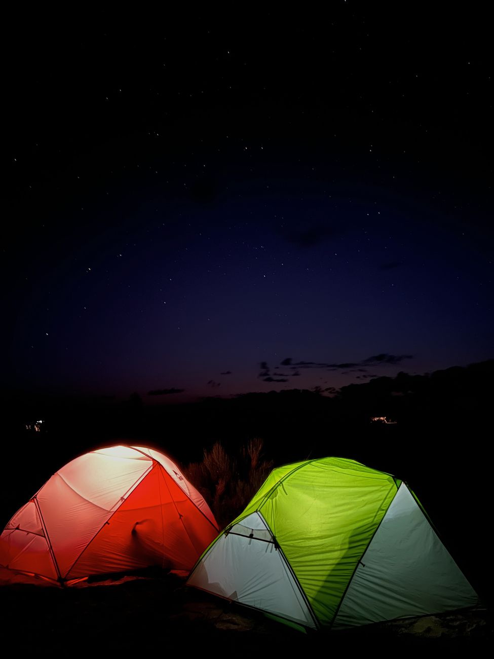 Two lit tents under a sky full of stars