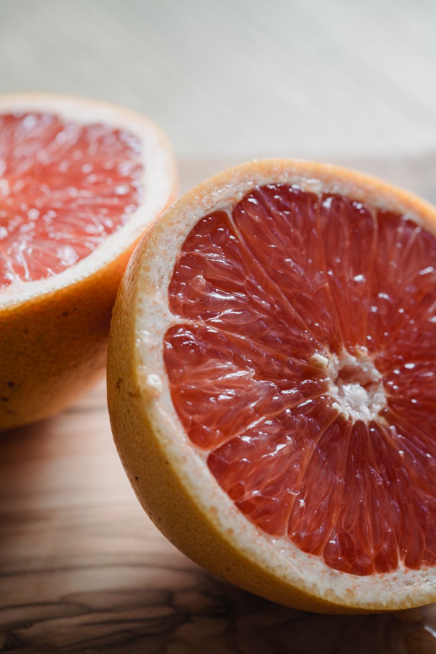 Halved pink grapefruit showing its ruby flesh