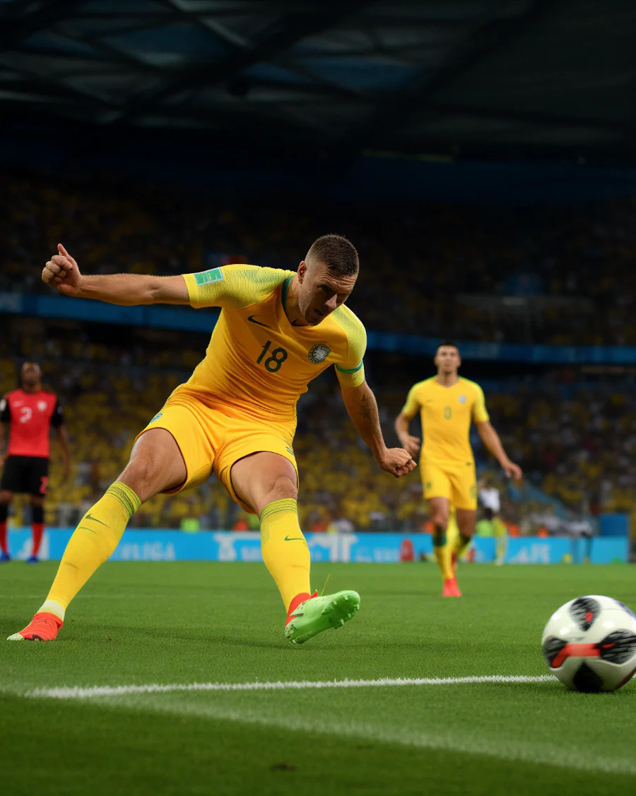 A striker connecting with the ball in front of a full stand