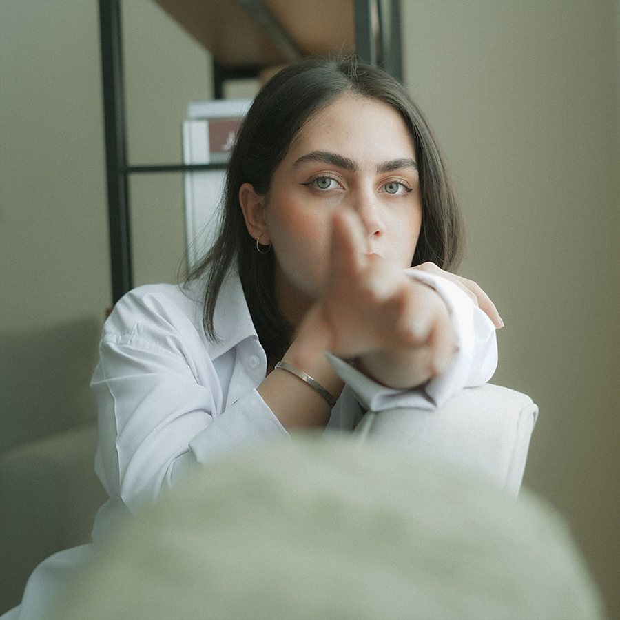 Lena Voss, co-founder of Tendon, pointing towards the camera in a white shirt