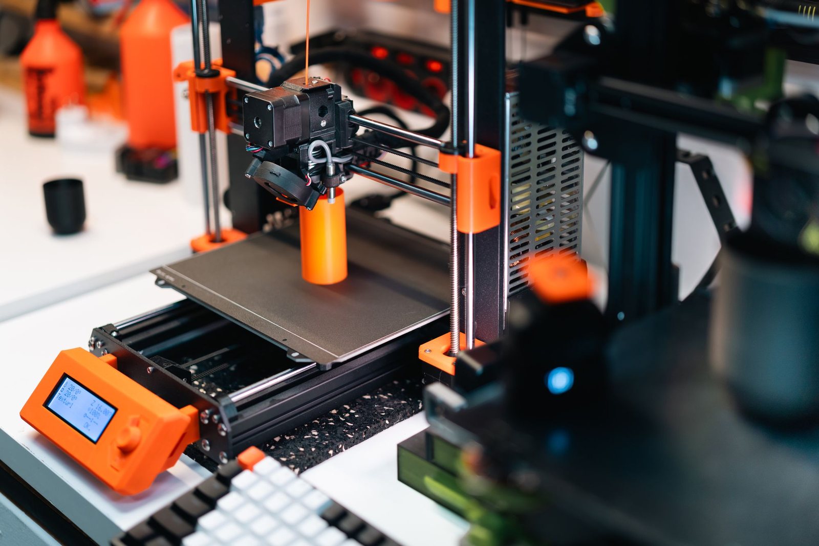 A row of 3D printers building prototype parts in the workshop