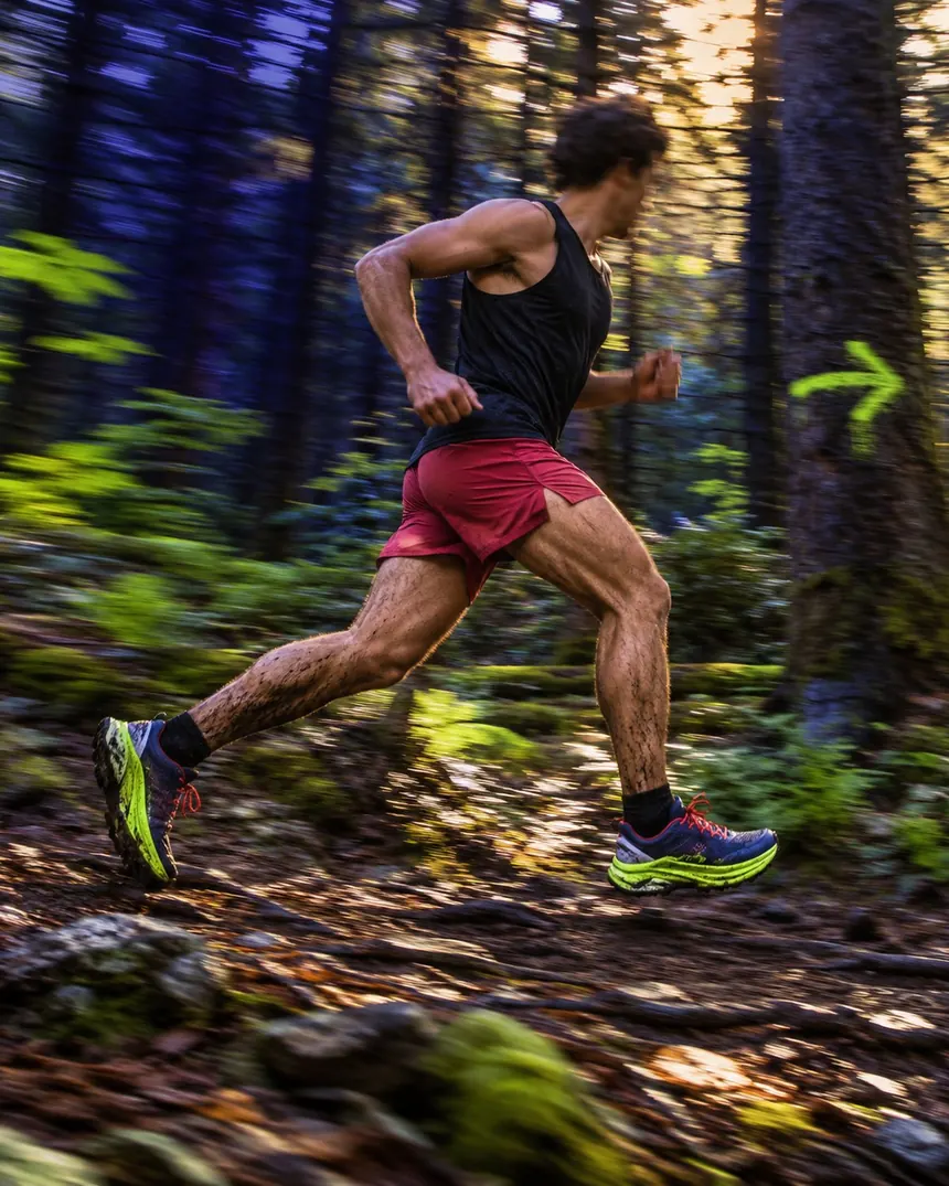 A runner blurred by speed on a forest switchback
