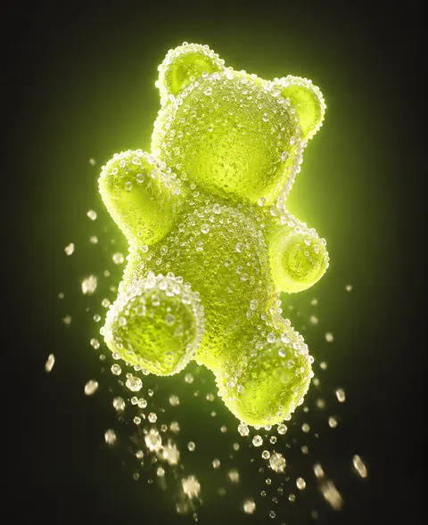 Lime sour gummy bear on a green glow