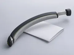 The slim graphite headband resting on a folded sheet of paper