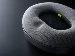 Macro of a fog-grey knitted ear cushion slowly recovering from a thumb press
