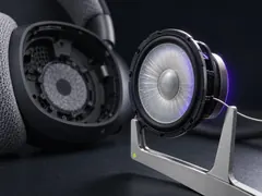 A 40 millimetre headphone driver held upright in a brushed metal jig