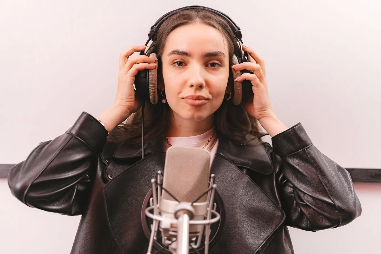 Juno Vale in the studio wearing headphones against a white backdrop
