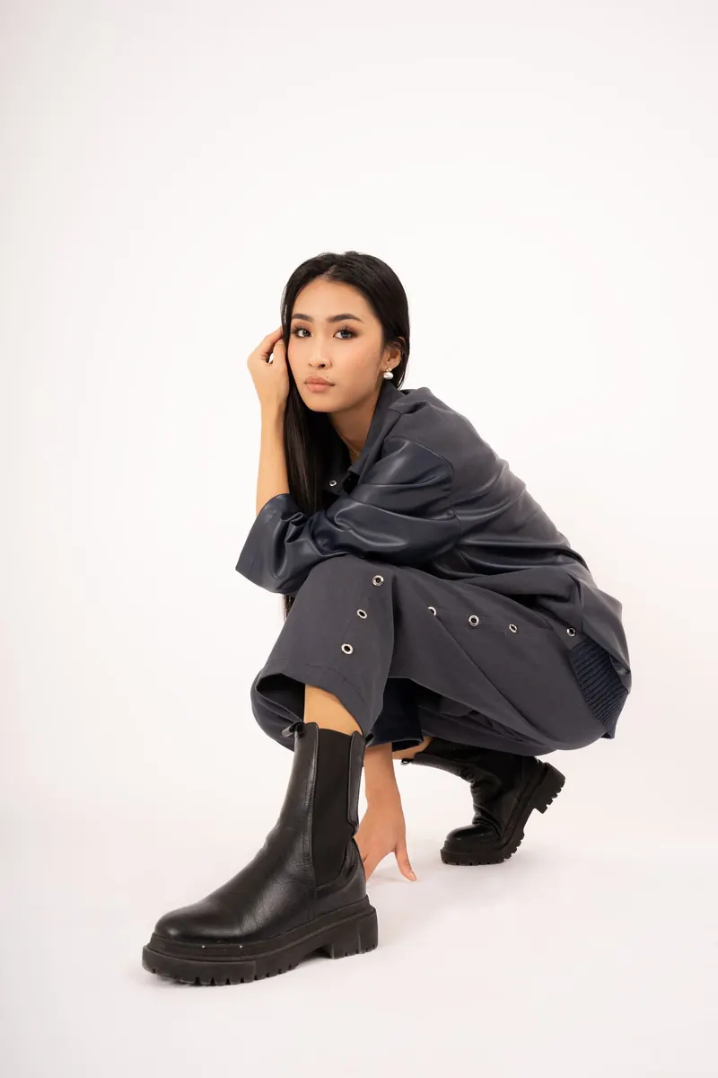 Model in black with chunky black boots