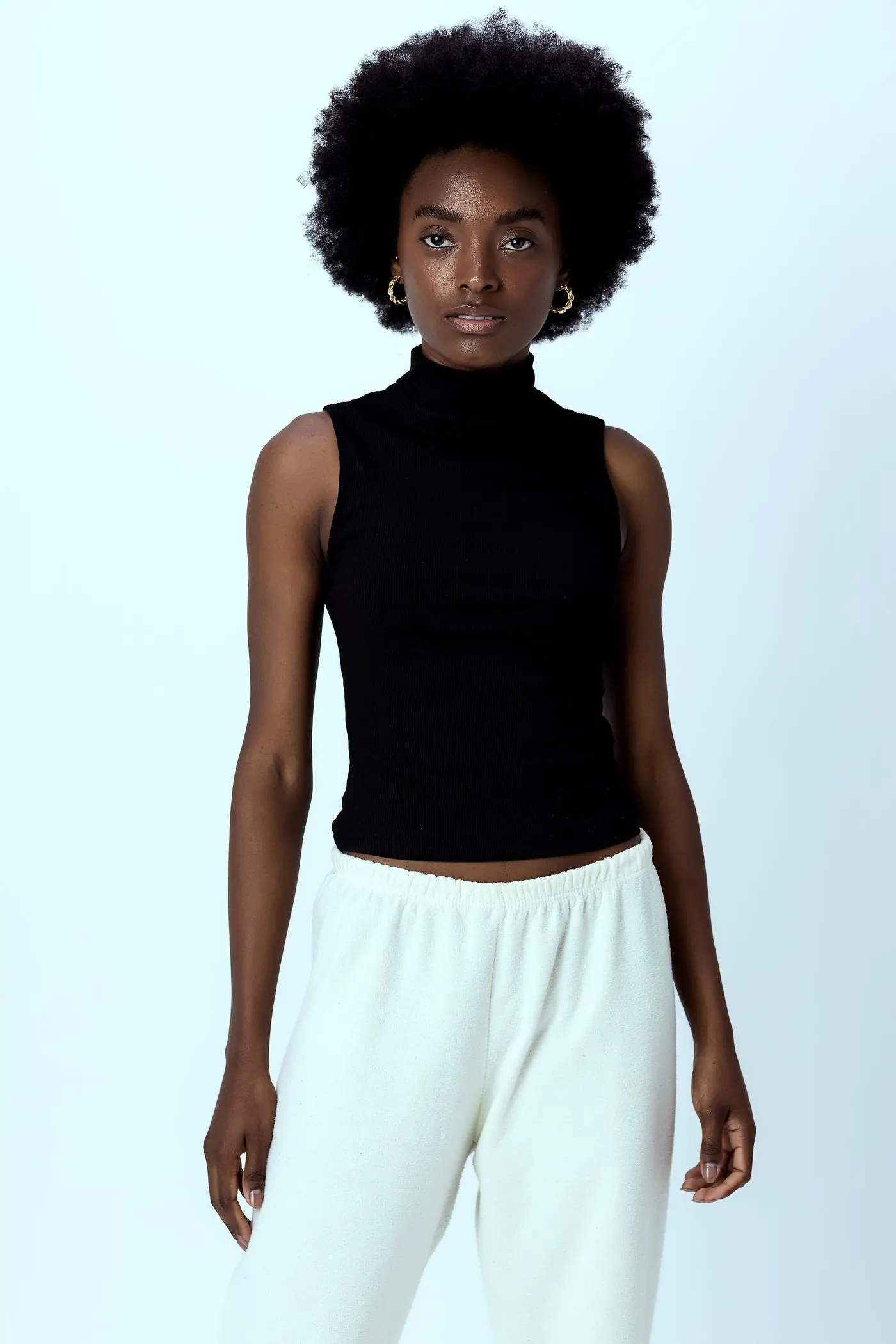 Black sleeveless mock-neck top in a studio