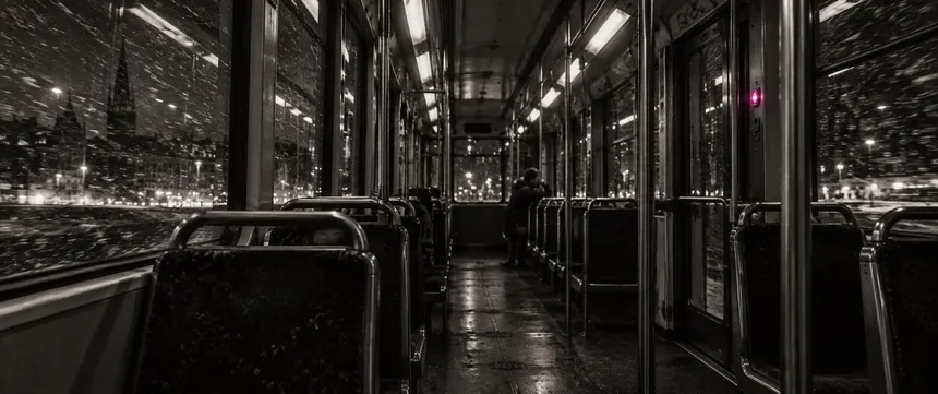 The inside of a night tram, snow streaking past the windows