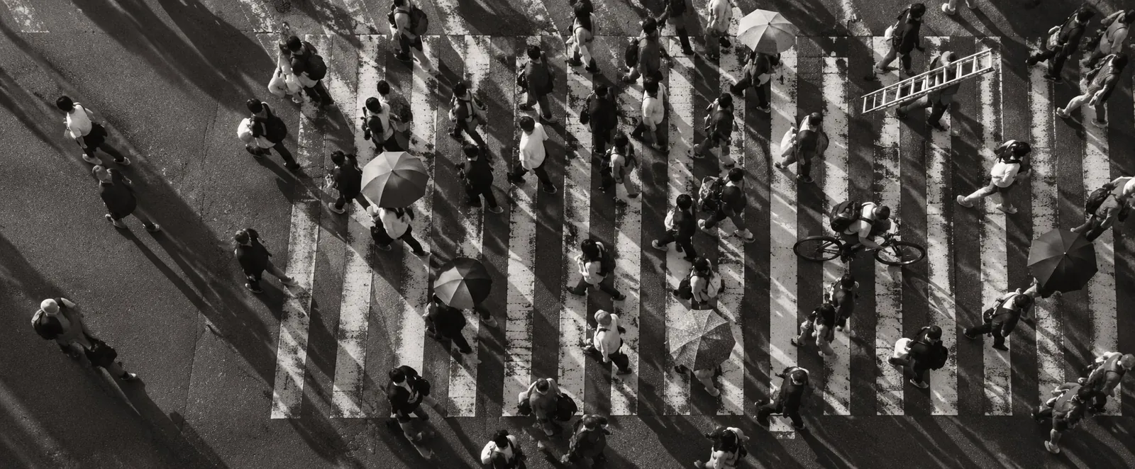 A busy street crossing seen from high above, people criss-crossing