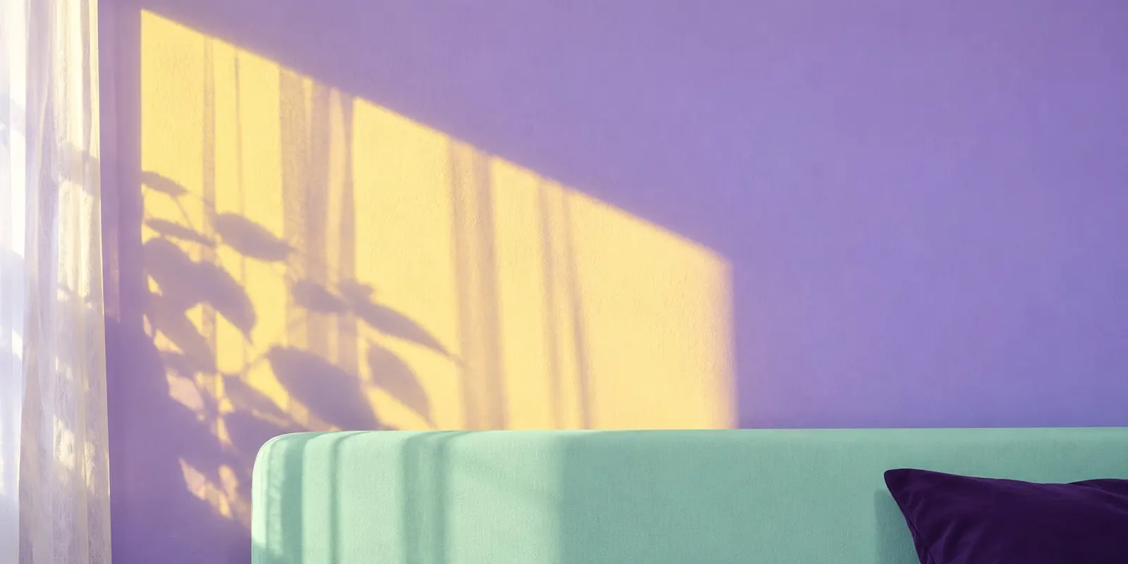 Butter-yellow dawn light falling across a lilac bedroom wall