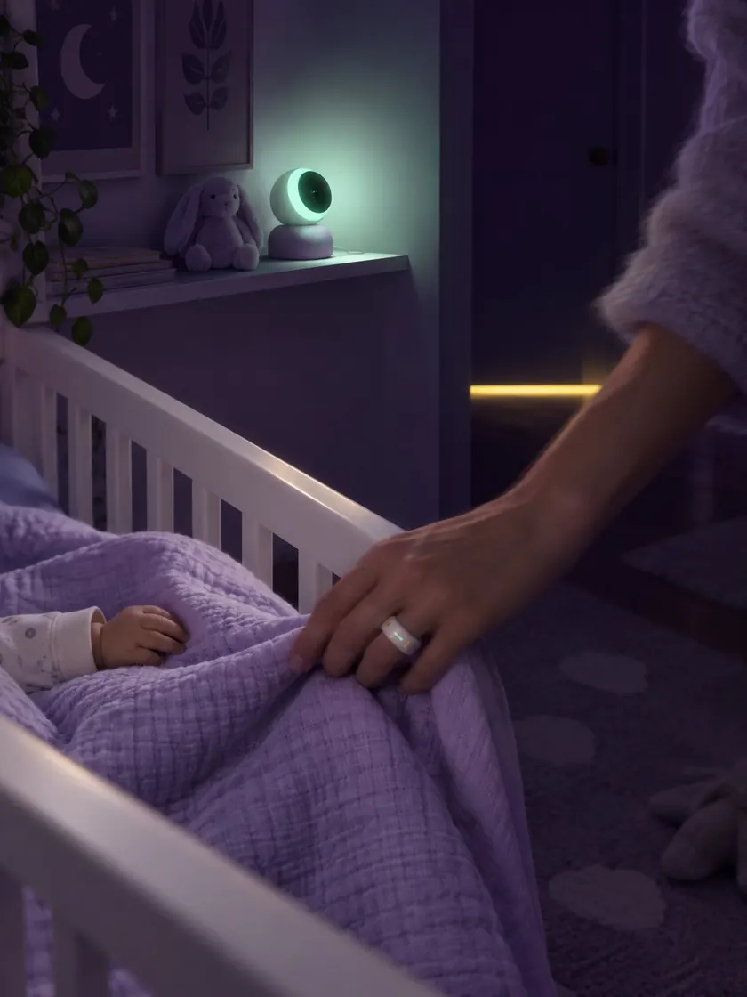 A nursery at night lit by the soft mint glow of a baby monitor
