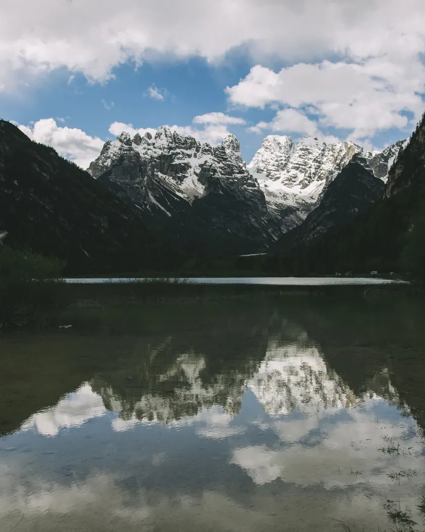 Still alpine lake reflecting the jagged Dolomite peaks