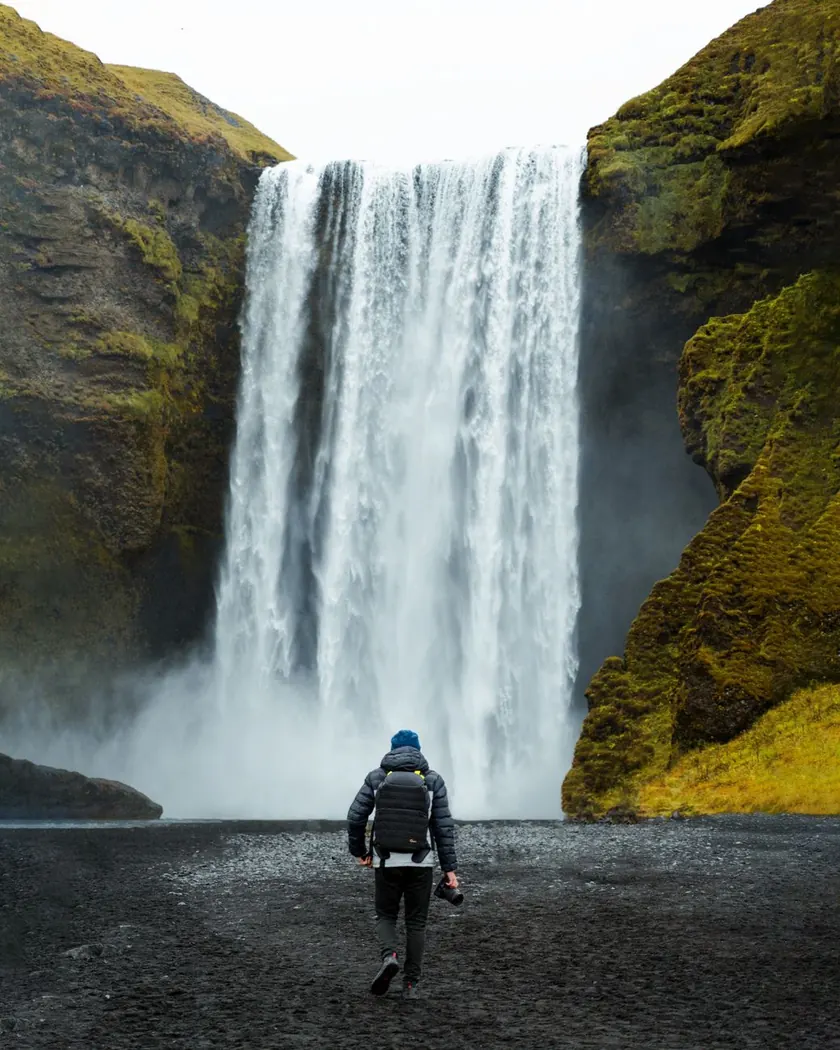Skógafoss waterfall pouring over green cliffs on Iceland's south coast