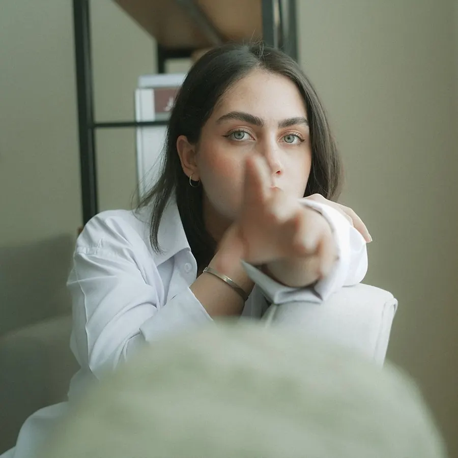 Lena Voss, co-founder of Tendon, pointing towards the camera in a white shirt