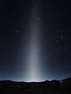 A faint cone of zodiacal light rising in the east before dawn